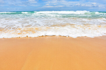 Fototapeta na wymiar The smooth sandy beach with beautiful waves as the background.