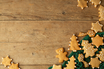 christmas gingerbread cookies lie in a green string bag on a light brown wooden background