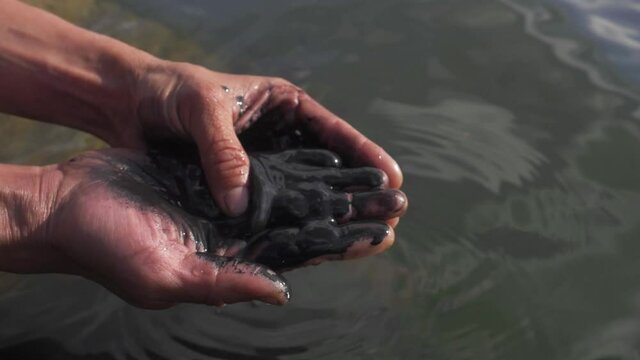 Slick industry oil fuel spilling water pollution. environmental pollution - research. oil in human hands, ecology anf environment.