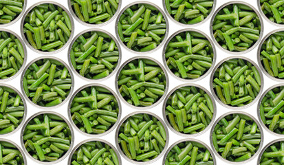 Seamless food background of flat lay view at opened tin cans with green beans isolated on white...