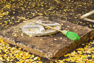 Street broom is on the ground. Street cleaning tool. Cleaning of autumn leaves.
