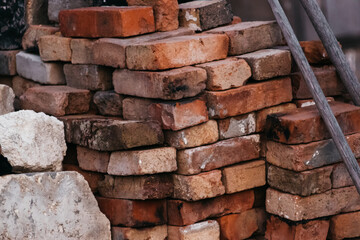 Bricks for construction. A lot of old red and orange bricks are stacked on top of each other.