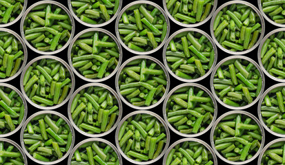 Seamless food background of flat lay view at opened tin cans with green beans isolated on black background. Clipping path added
