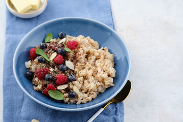 Oatmeal with raspberries, blueberries, honey, almond petals and chia seeds. Healthy breakfast.