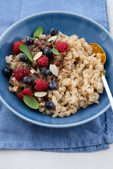 Oatmeal with raspberries, blueberries, honey, almond petals and chia seeds. Healthy breakfast.