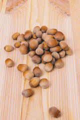 Pile of nuts. Hazelnuts. Whole nuts. Corylus avellana. Macro photo, close up, on wooden table.