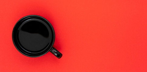 Top view, flat lay of black coffee cup on background red.