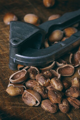 Nutcracker, whole nuts, shelled nuts and shells. Corylus avellana. Macro photo, close up, on wooden table.