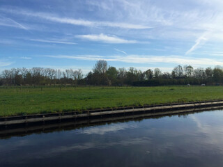 Obraz premium the river near meadow against blue sky in the village of Giethoorn, Holland Netherlands