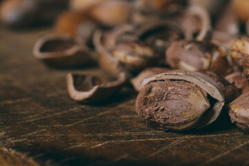 Whole nuts, shelled nuts and shells. Corylus avellana. Macro photo, close up, on wooden table.
