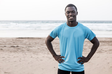 Happy African American sportsman on beach