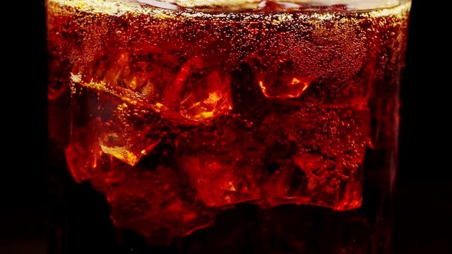 Glass of Cola with ice and bubbles.