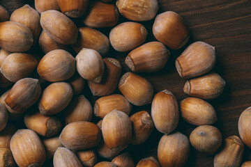 Pile of nuts. Whole nuts. Hazelnuts.Macro photo, close up, top view on wooden table.