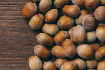 Pile of nuts. Whole nuts. Hazelnuts.Macro photo, close up, top view on wooden table.