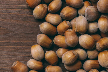 Pile of nuts. Whole nuts. Hazelnuts.Macro photo, close up, top view on wooden table.
