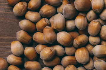 Pile of nuts. Whole nuts. Hazelnuts.Macro photo, close up, top view on wooden table.