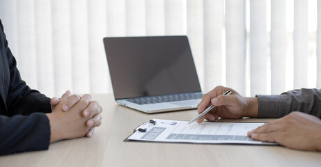 HR head is interviewing a young man's job application in a private room.