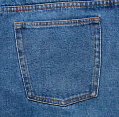 back pocket of blue jeans with brown thread seams