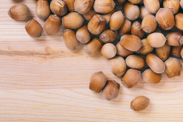 Pile of nuts. Whole nuts. Corylus avellana. Macro photo, close up, top view on wooden table.
