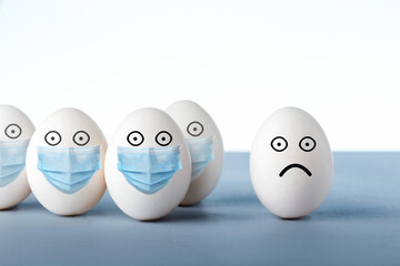 Some eggs with medical mask and egg without mask, virus infections prevention and protection concept.