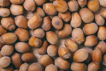 Pile of nuts. Whole nuts. Corylus avellana. Macro photo, close up, top view on wooden table.