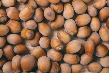 Pile of nuts. Whole nuts. Corylus avellana. Macro photo, close up, top view on wooden table.