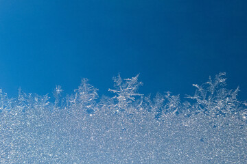 Abstract view of frost on window surface. Blue crystal frost texture. Cold winter background. Nobody