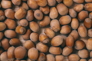 Pile of nuts. Whole nuts. Corylus avellana. Macro photo, close up, top view on wooden table.