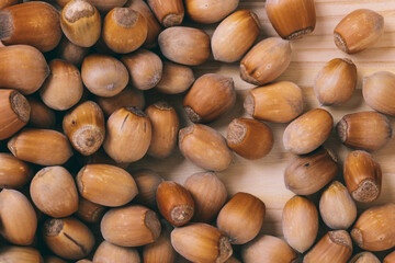 Pile of nuts. Whole nuts. Corylus avellana. Macro photo, close up, top view on wooden table.