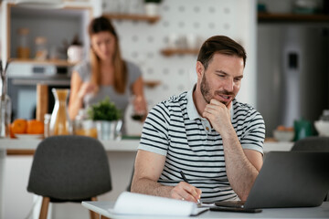 Young man working on project. Handsome man working at home