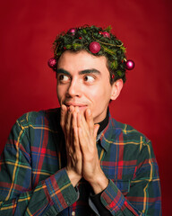 man in a plaid shirt on a red background in new year costume christmas mood green hair funny