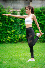 Young asian women warm up in a park before jogging.