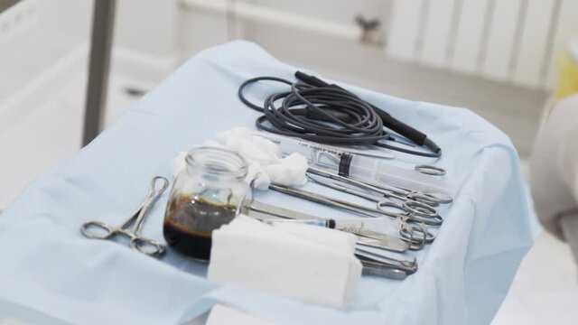 Close up of sterile surgical tools for laparoscopic surgery. Action. Tools for medical surgery with the glass bowl of iodine, concept of health and medicine.