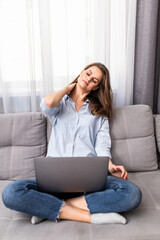 Frustrated sad woman feeling tired worried about problem sitting on sofa with laptop.