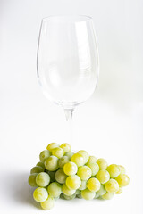 Bunch of ripe and juicy green grapes close-up in wine glass on a white background