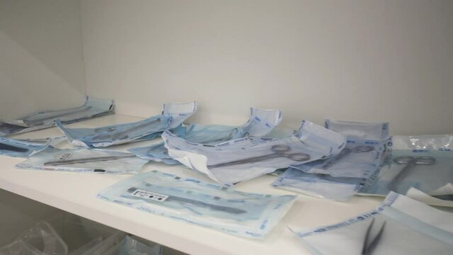 Medical laboratory details, a set of sterile disposable instruments lying on the table. Action. Close up of medical tools, surgical equipment, concept of medicine.