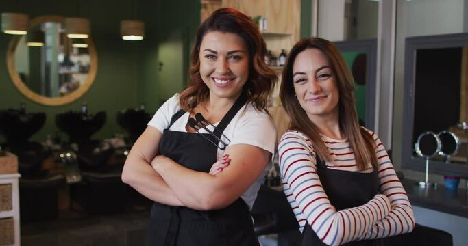 Portrait of two Female hairdressers smiling at hair salon