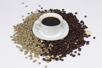 Black coffee is served in a glass cup, which is placed on top of the coffee beans. There are coffee beans that have been roasted and are still fresh beans.