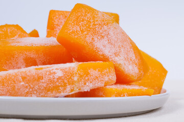 Frozen pieces of pumpkin on the plate.