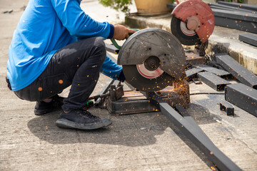 The technician is using the Steel cutting machine to cut steel on the construction site.