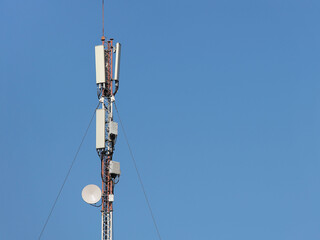 Obraz premium Radio-television tower for receiving and transmitting electromagnetic signals at a distance. Metal high-tech construction shrouded in a white cloud. The source of the pulse frequency