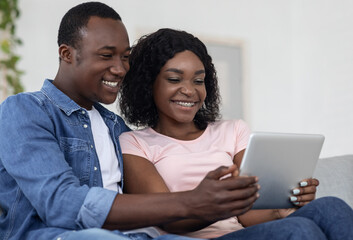 Obraz premium Closeup of black family using digital tablet