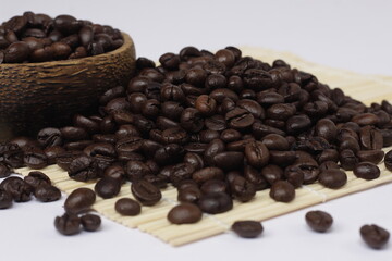 pile of roasted coffee beans, exotic black and emitting a distinctive aroma of coffee.