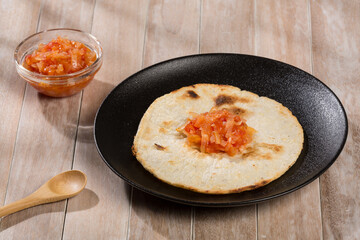 White corn arepa with hogao - tasty Colombian breakfast.