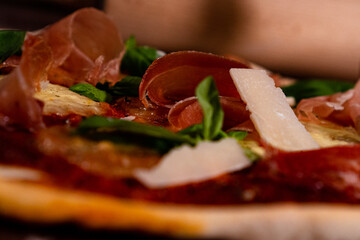 Handmade pizza parma mozzarella, ham and parmesan close up on the table with flour and decoration,...