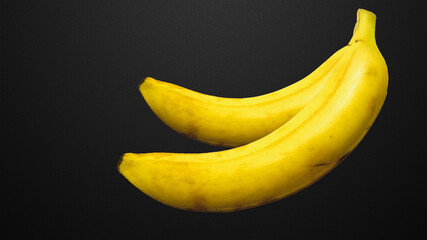 Two yellow bananas on a black background 