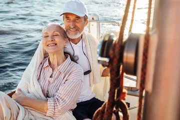 Rolgordijnen Happy mature couple enjoying their vacation on a sailboat © Artem Varnitsin