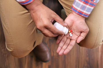 Close up of man hand taking medicine 