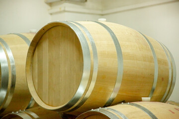 Wooden wine barrels are found at the winery. They are ready to pour or are already filled.