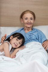 Obraz na płótnie Canvas Asian Lovely girl visit and encourage grandmother on patient bed in hospital